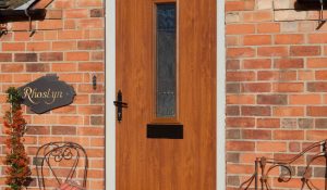 Composite entrance door in oak colour finish and black traditional hardware