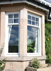 Tall white uPVC vertical sliding sash windows with sash horns Poole