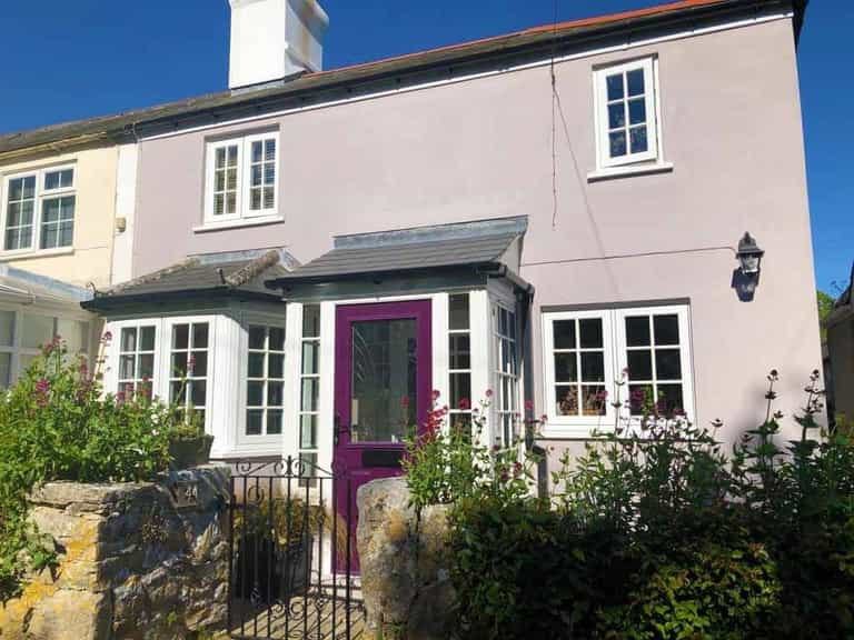 Weymouth cottage with a purple composite front door and flush sash windows